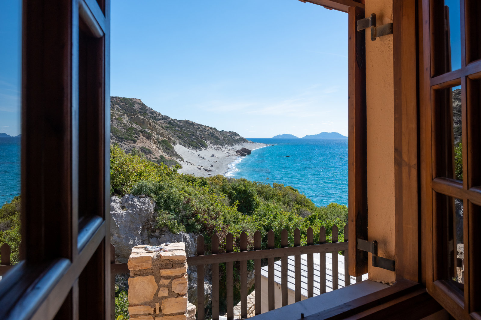 Sea view over Ligres Beach framed by a studio window